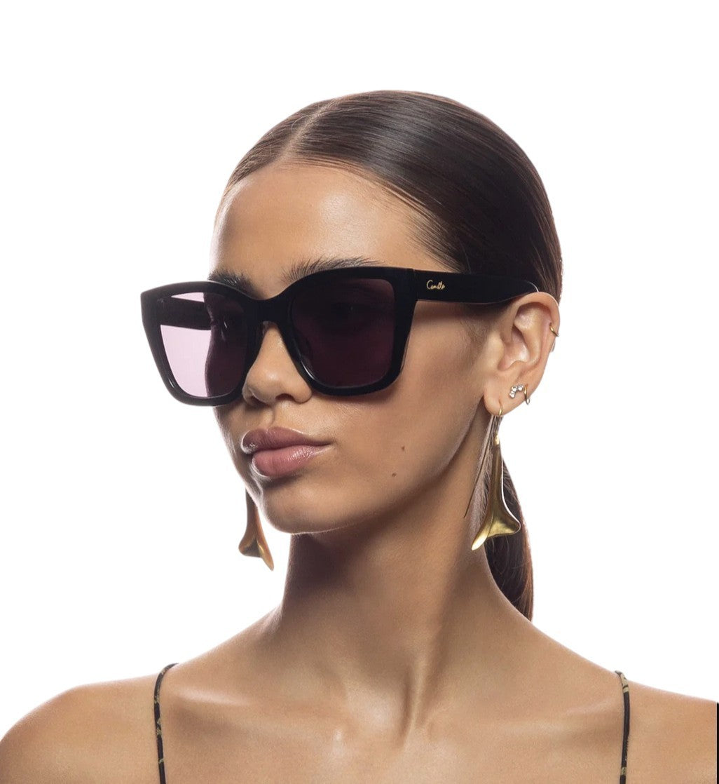 Woman wearing Celine sunglasses with a plain background