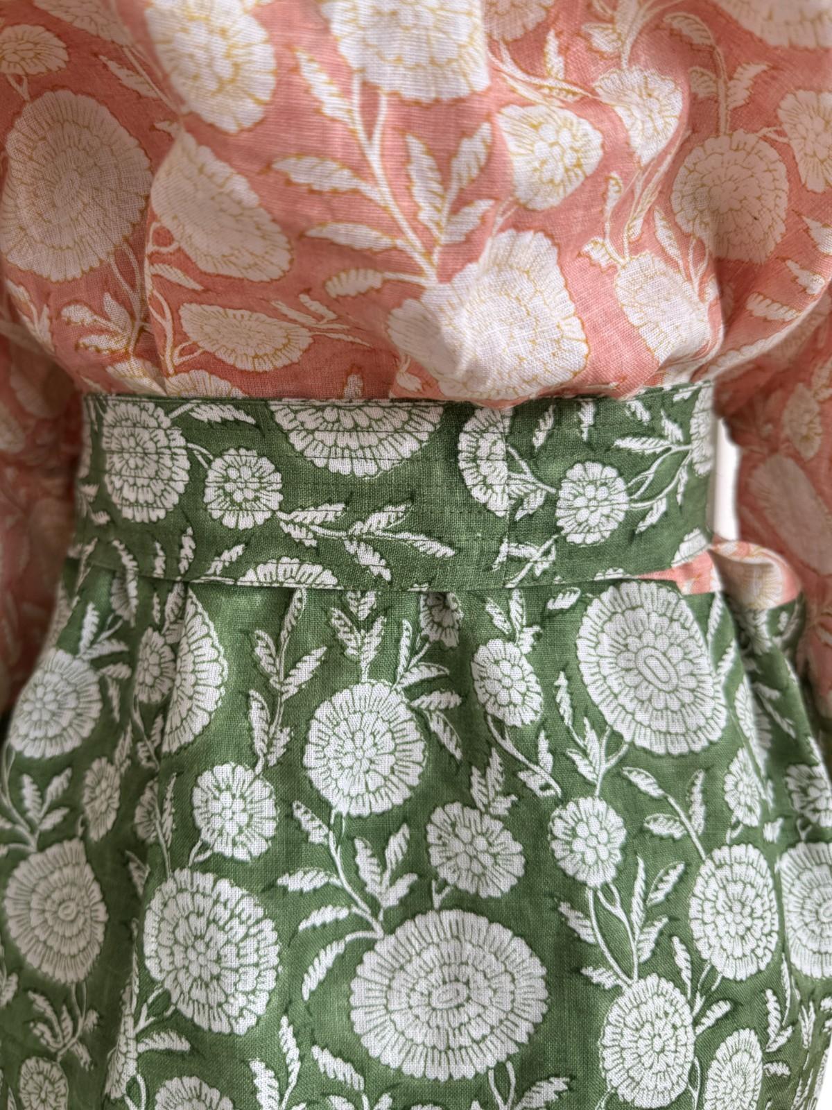 Close-up of floral-patterned fabric with pink and green colors.
