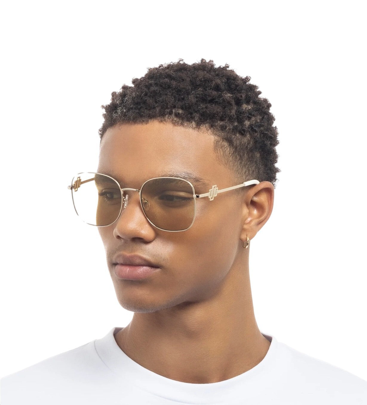 Person wearing gold-framed glasses on a white background