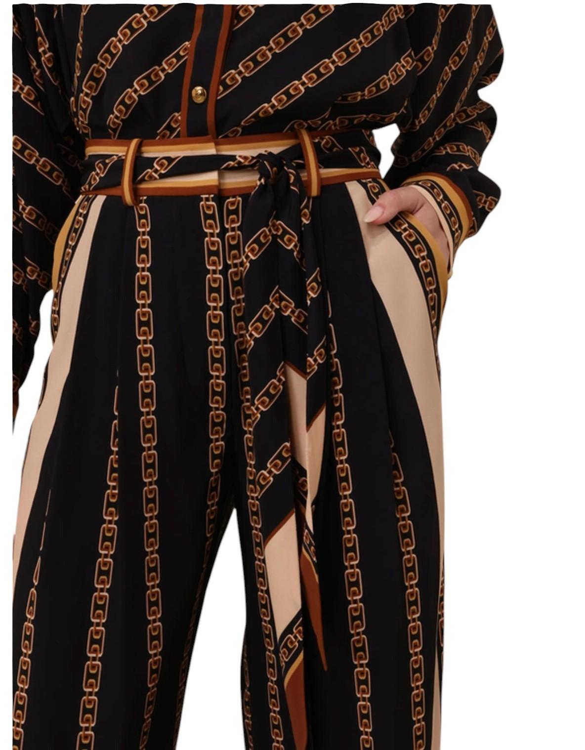 Black pants with gold chain pattern and beige accents on a hanger.