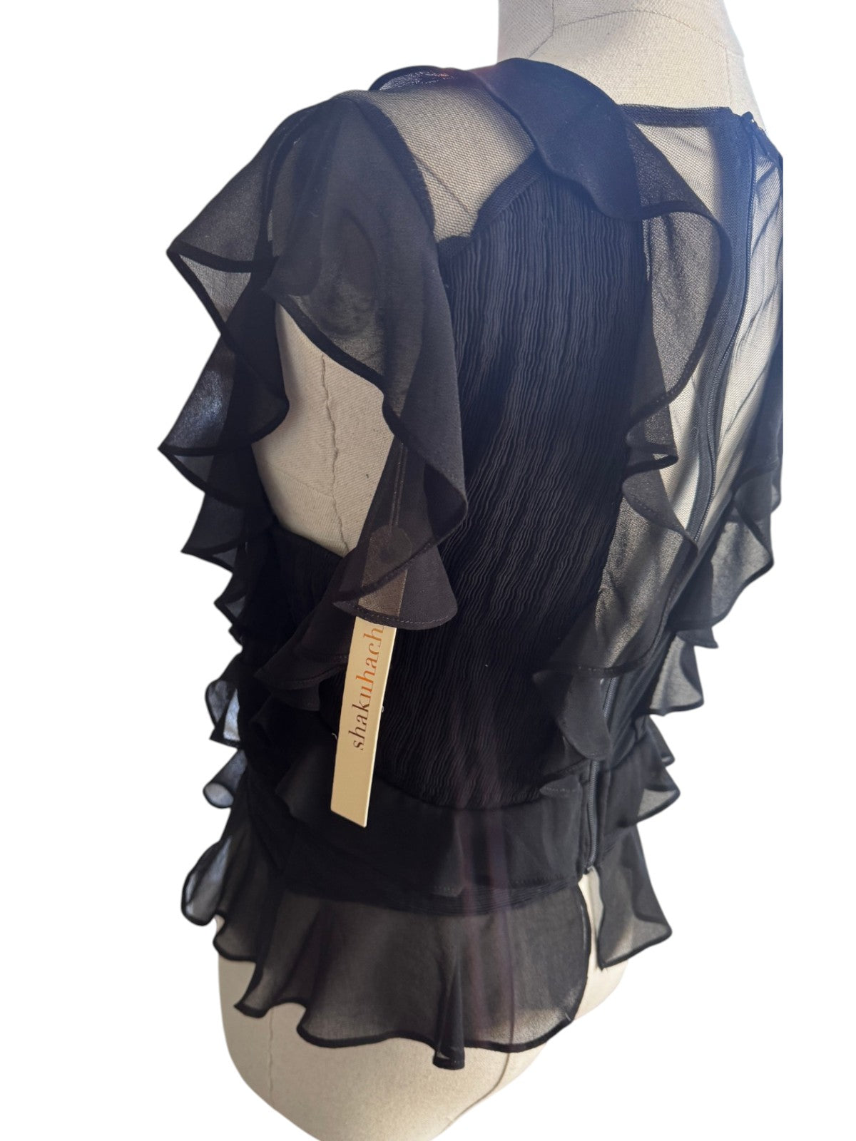 Naked Pear Shakuhachi black pleated mesh top with ruffled frill details and sheer inserts on a mannequin