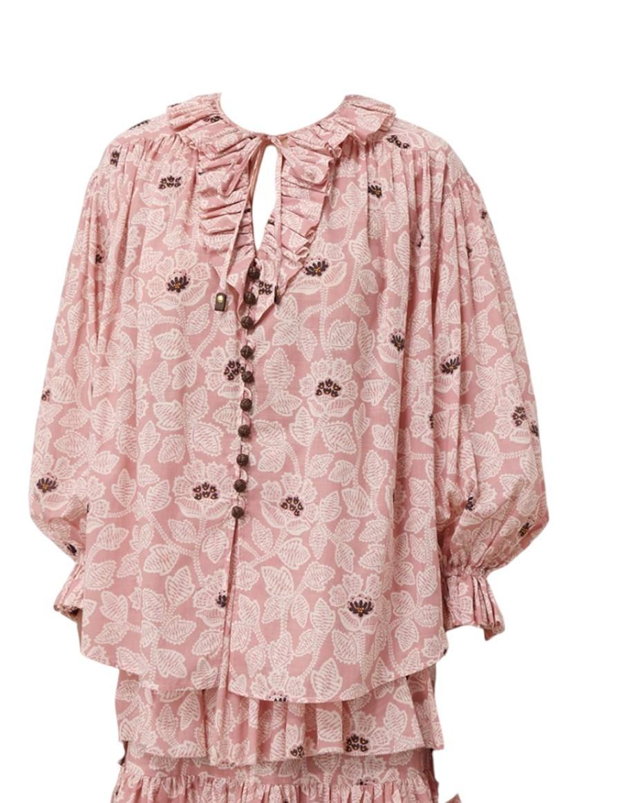 Pink floral blouse with ruffled collar on a white background