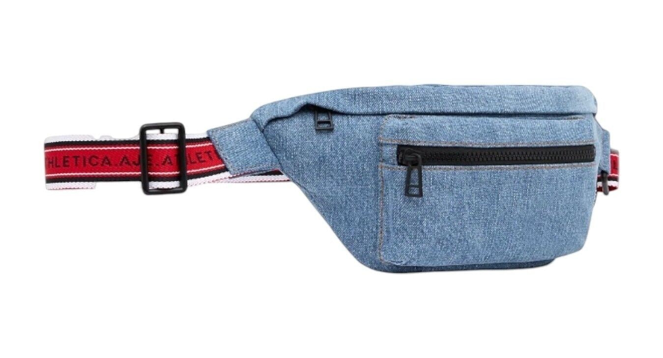Naked Pear Aje. Athletica blue denim crossbody bag with a red, black, and white logo strap and matte black hardware.