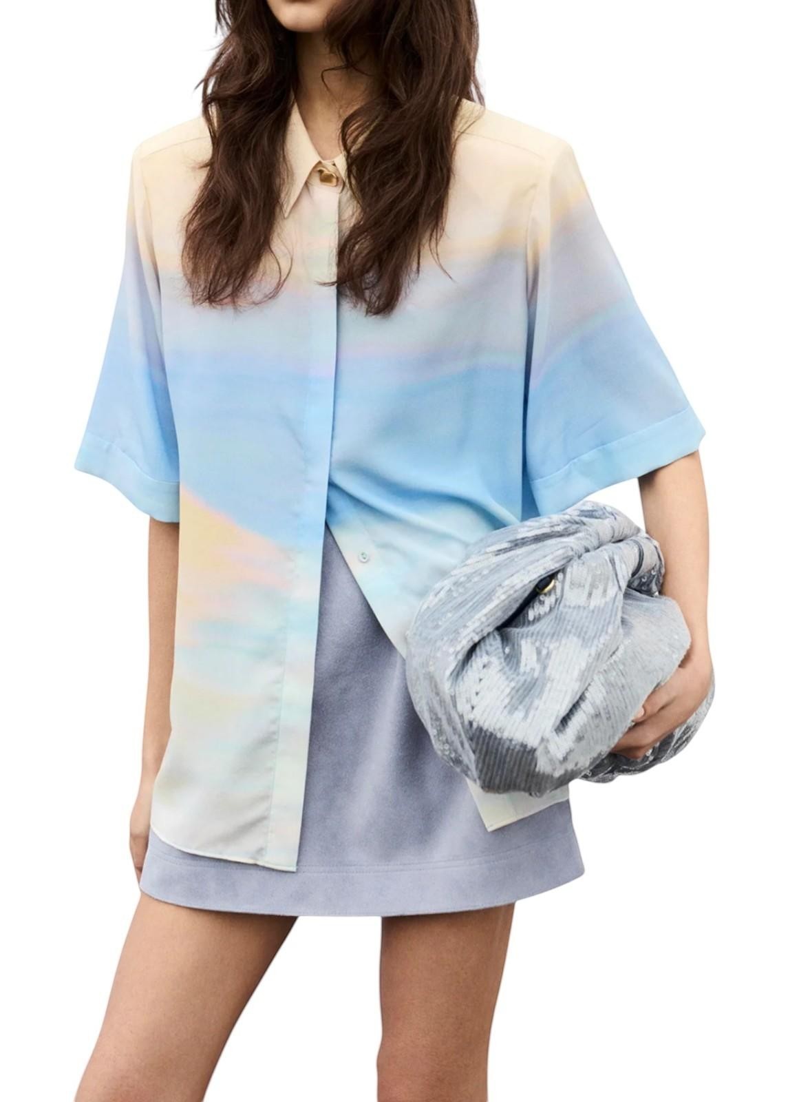 Naked Pear model holding an Aje Arden oversized slate blue sequin clutch bag with a magnetic frame closure