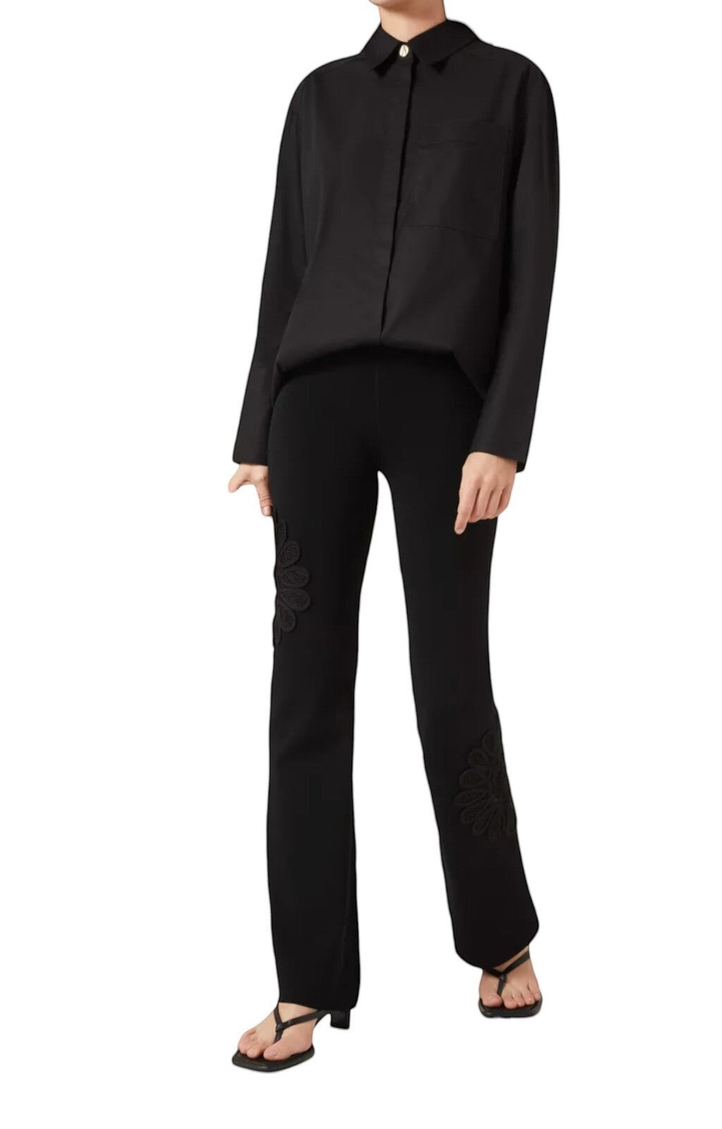 Naked Pear Aje black high-waisted knit pants featuring a flared silhouette and intricate floral lace leg detailing.