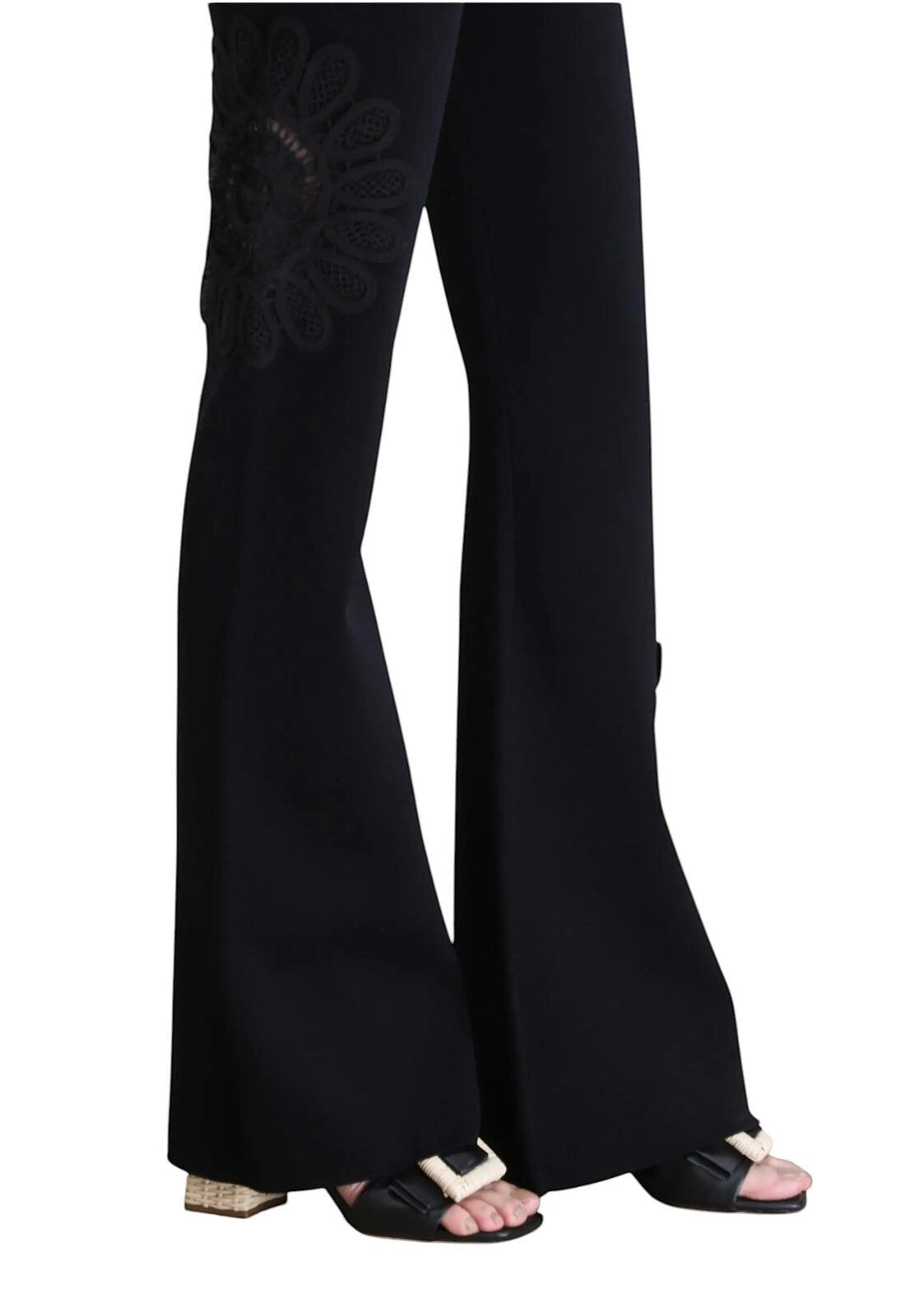 Naked Pear Aje black stretch knit flared pants with intricate lace flower leg detail and high-waisted silhouette