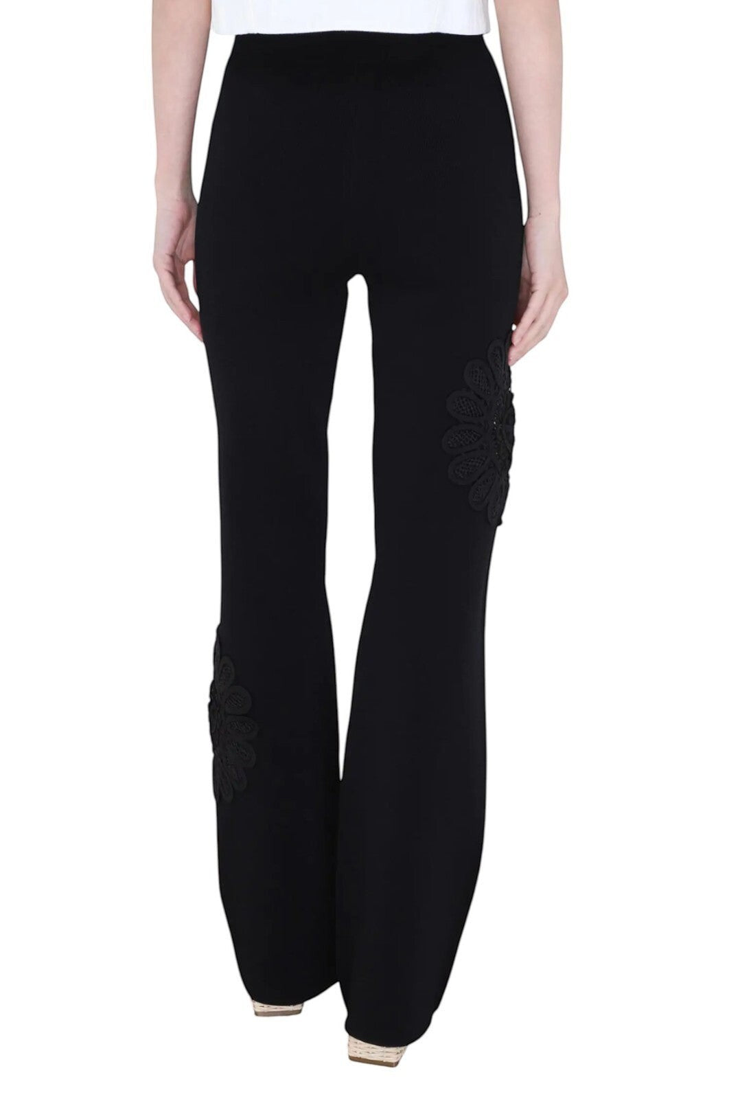 Naked Pear Aje black high-waisted knit pants featuring a flared silhouette and intricate lace flower leg details.
