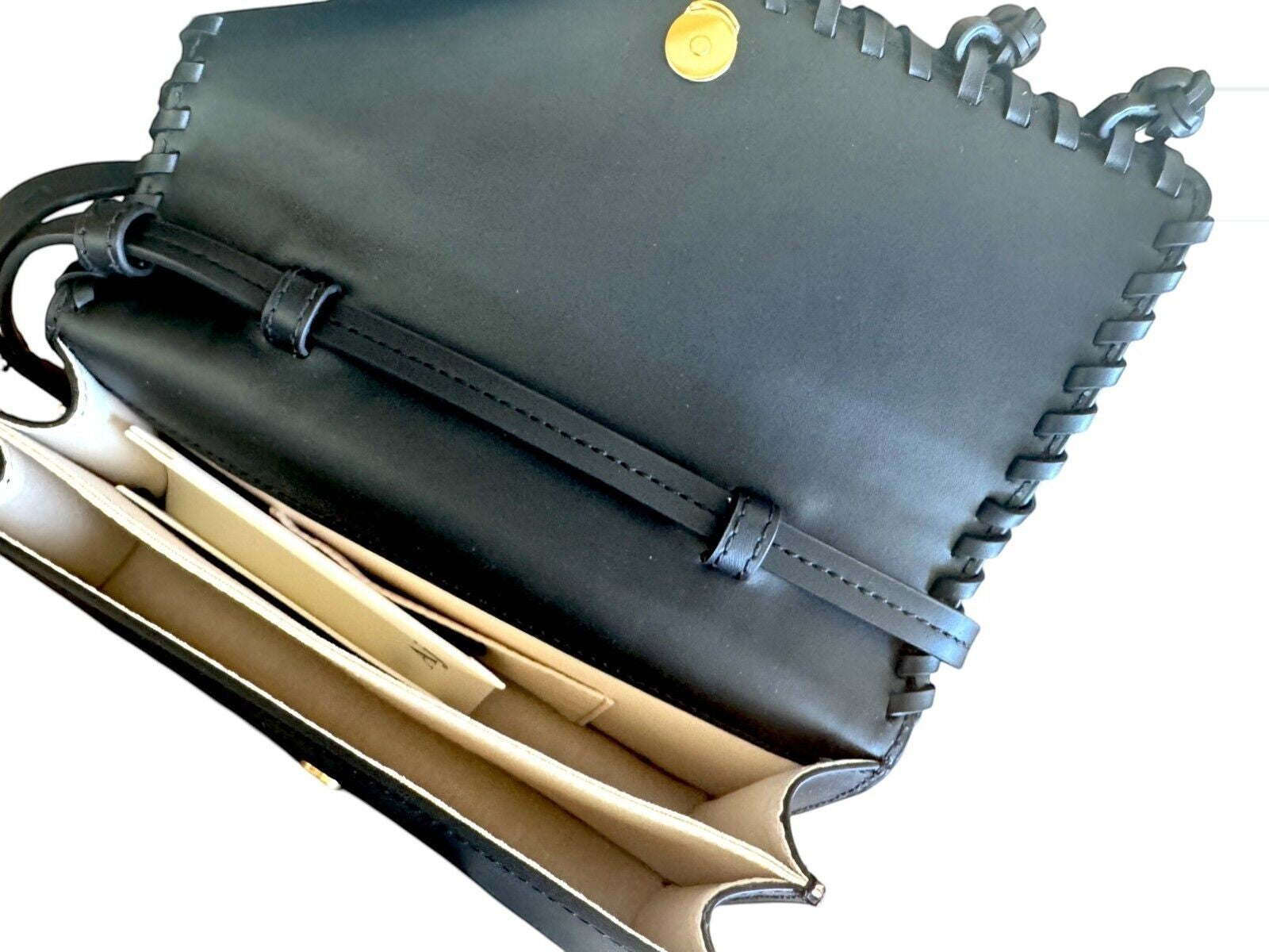 Naked Pear Aje black leather crossbody bag with flap opening, magnetic closure, and twin internal compartments.