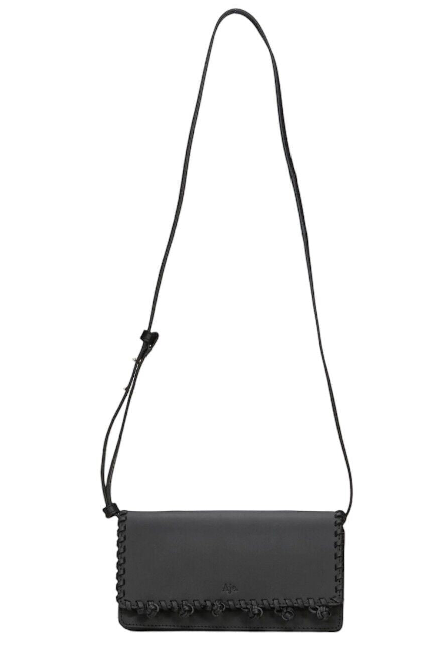 Naked Pear Aje black leather crossbody bag with tassel pom-pom trim and adjustable shoulder strap.