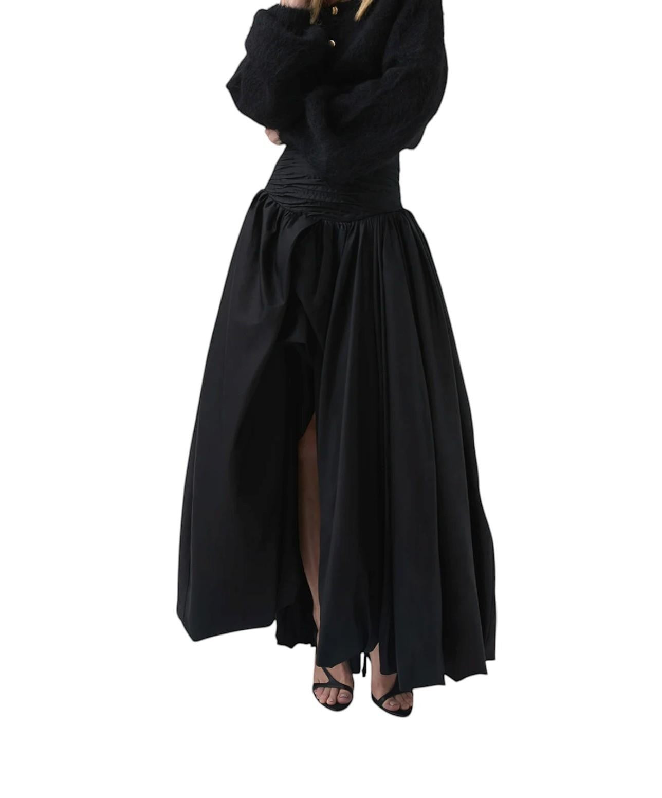 Naked Pear Aje black cotton maxi skirt featuring a ruched waist, asymmetric bubble hem, and front slit detail.