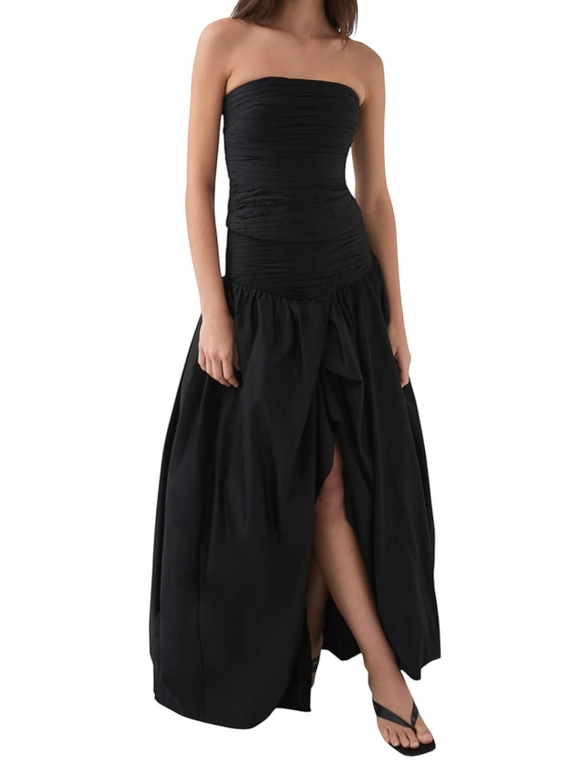 Naked Pear Aje black cotton maxi skirt with ruched waist, asymmetric bubble hem, and front slit on a model
