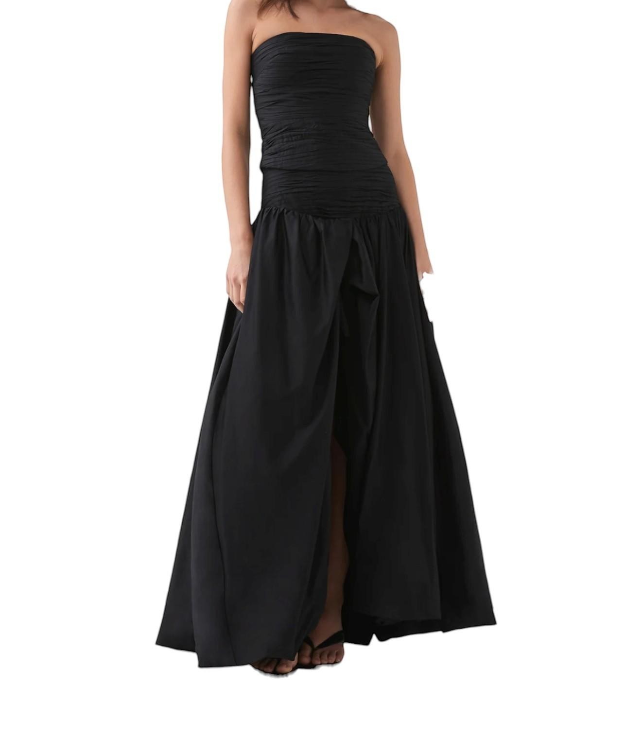 Naked Pear Aje black cotton maxi skirt with ruched waist, asymmetric bubble hem, and front slit on a model
