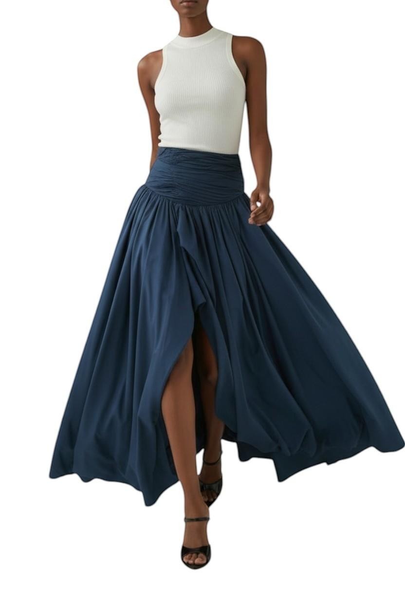 AI generated image of Model wearing a Naked Pear Aje slate blue cotton maxi skirt with a ruched waist, front slit, and bubble hem.