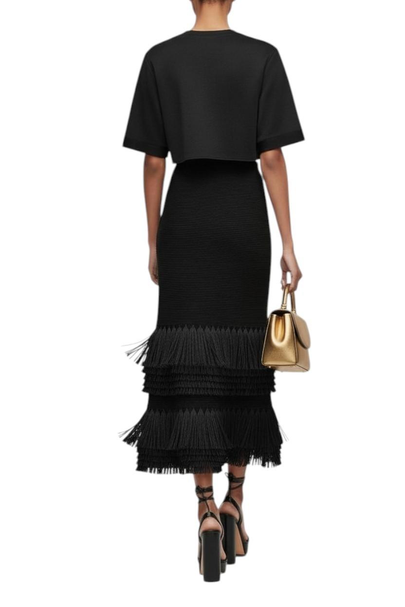AI generared image of Person wearing a black outfit with a fringed skirt and holding a gold handbag on a white background