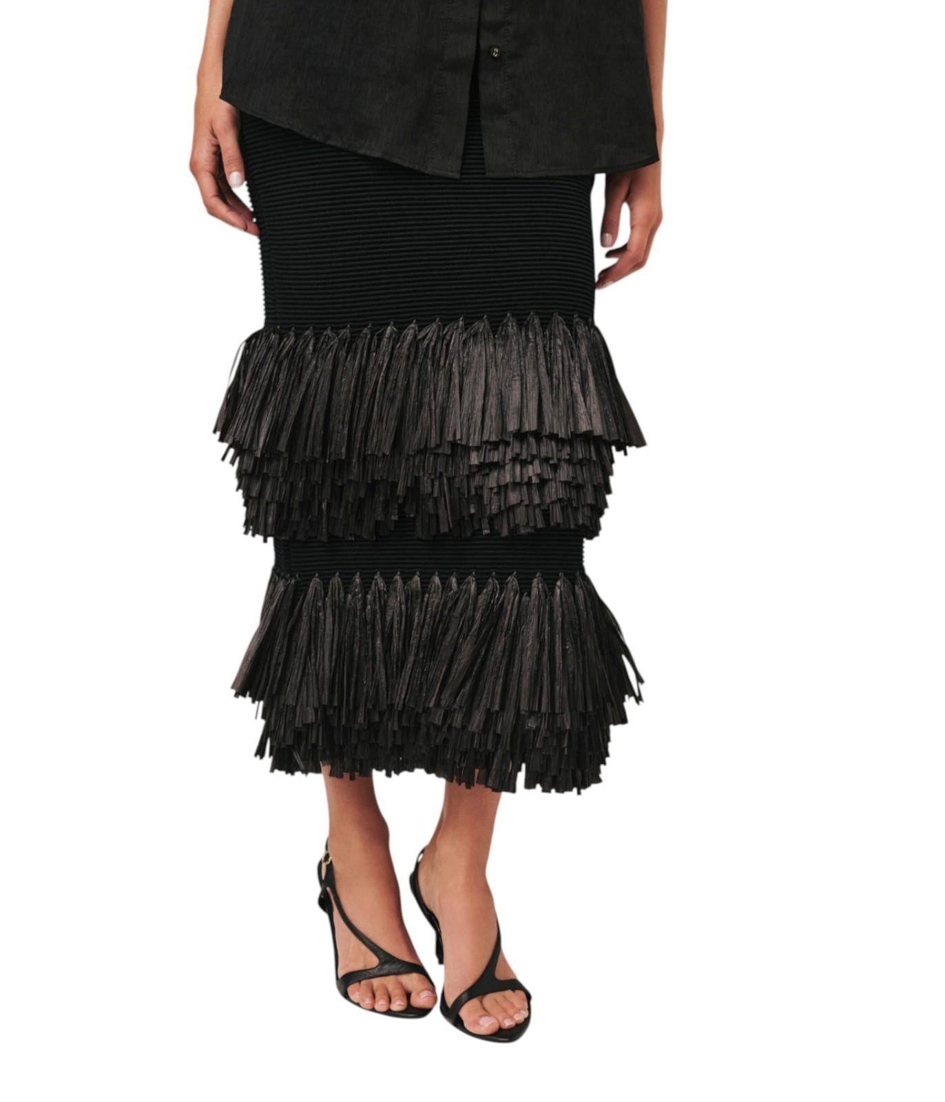 Black tiered skirt worn by a person on a white background