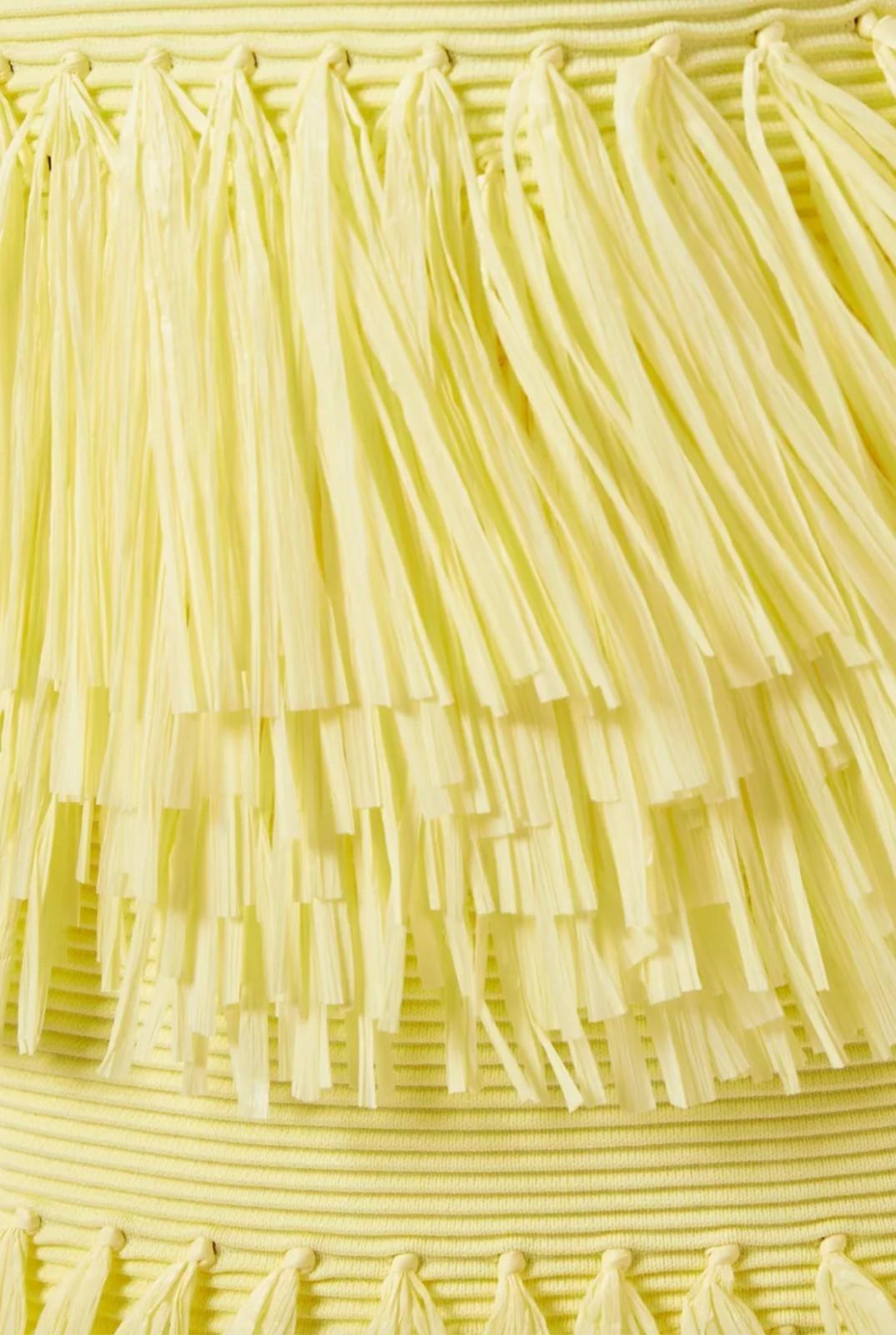 Close-up of a yellow textured fabric with tassels