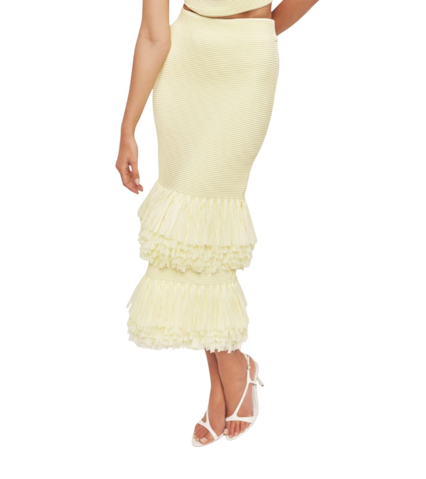 Yellow ruffled skirt worn by a person on a white background
