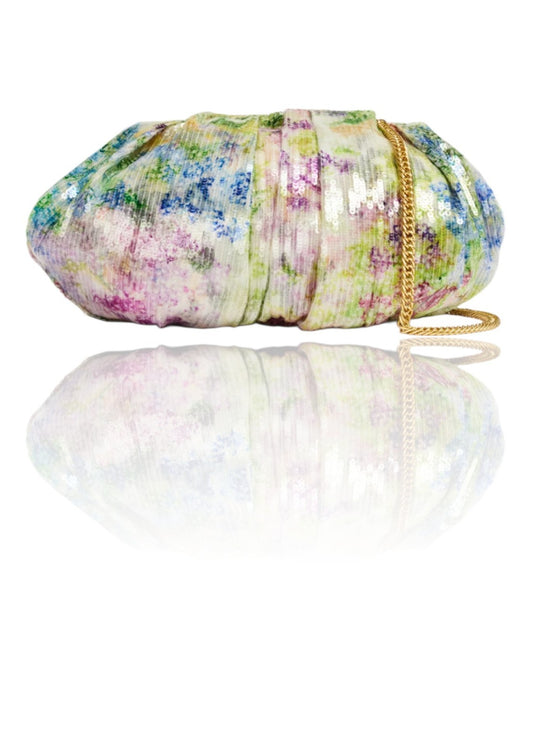 Floral patterned clutch bag with a chain strap on a white background