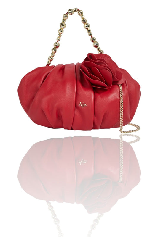 Red handbag with floral design and gold chain strap on a white background