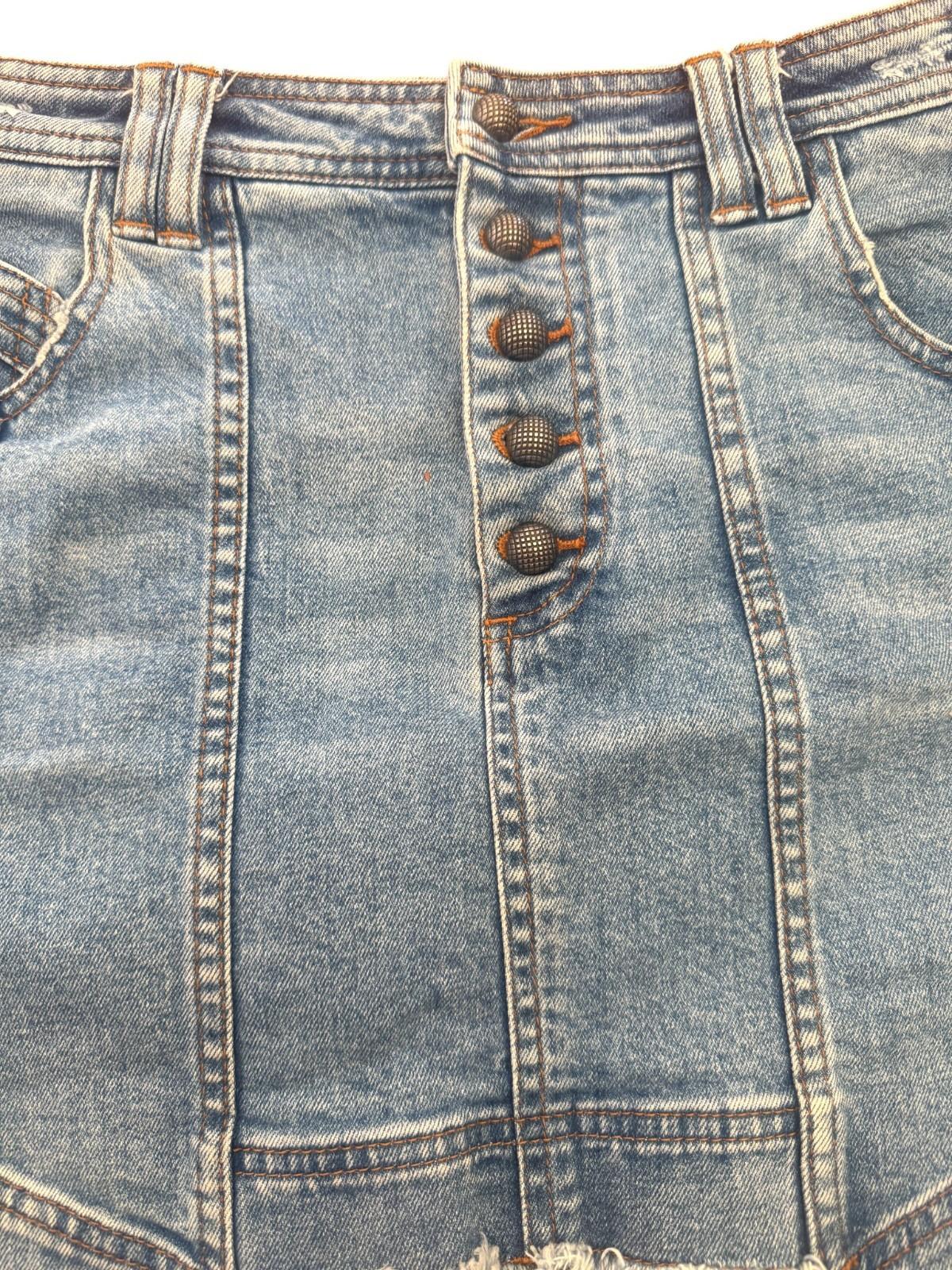 Close-up of a blue denim skirt with button details