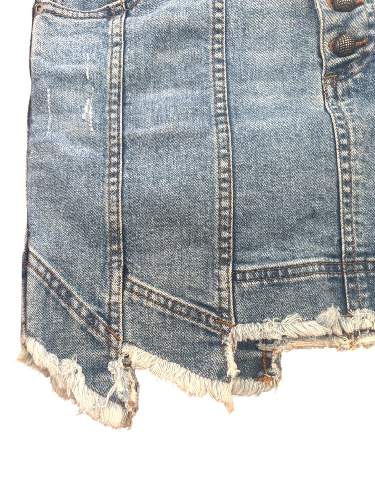 Close-up of a denim skirt with frayed hem on a white background