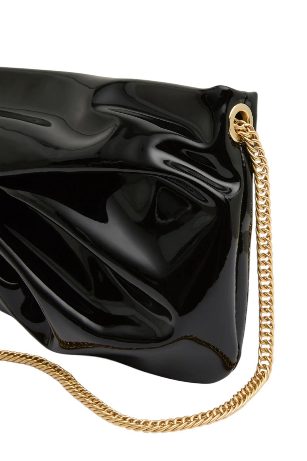 Black clutch bag with a gold chain on a white background