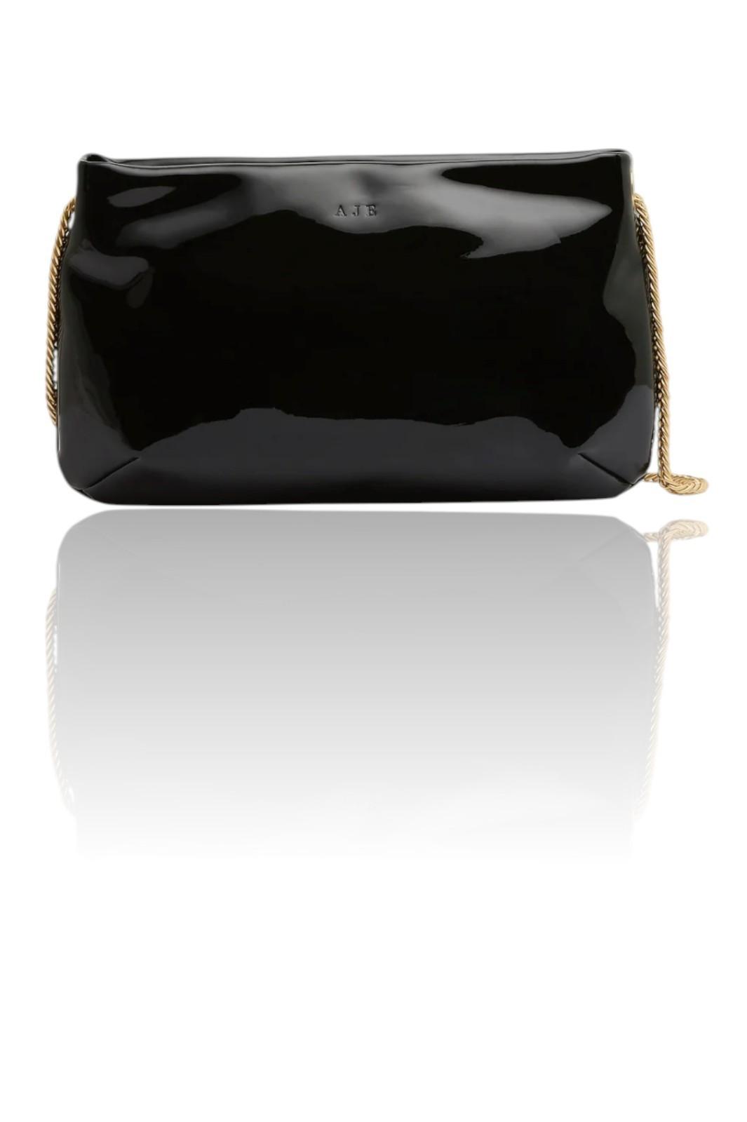 Black patent leather clutch bag with gold chain strap on a white background
