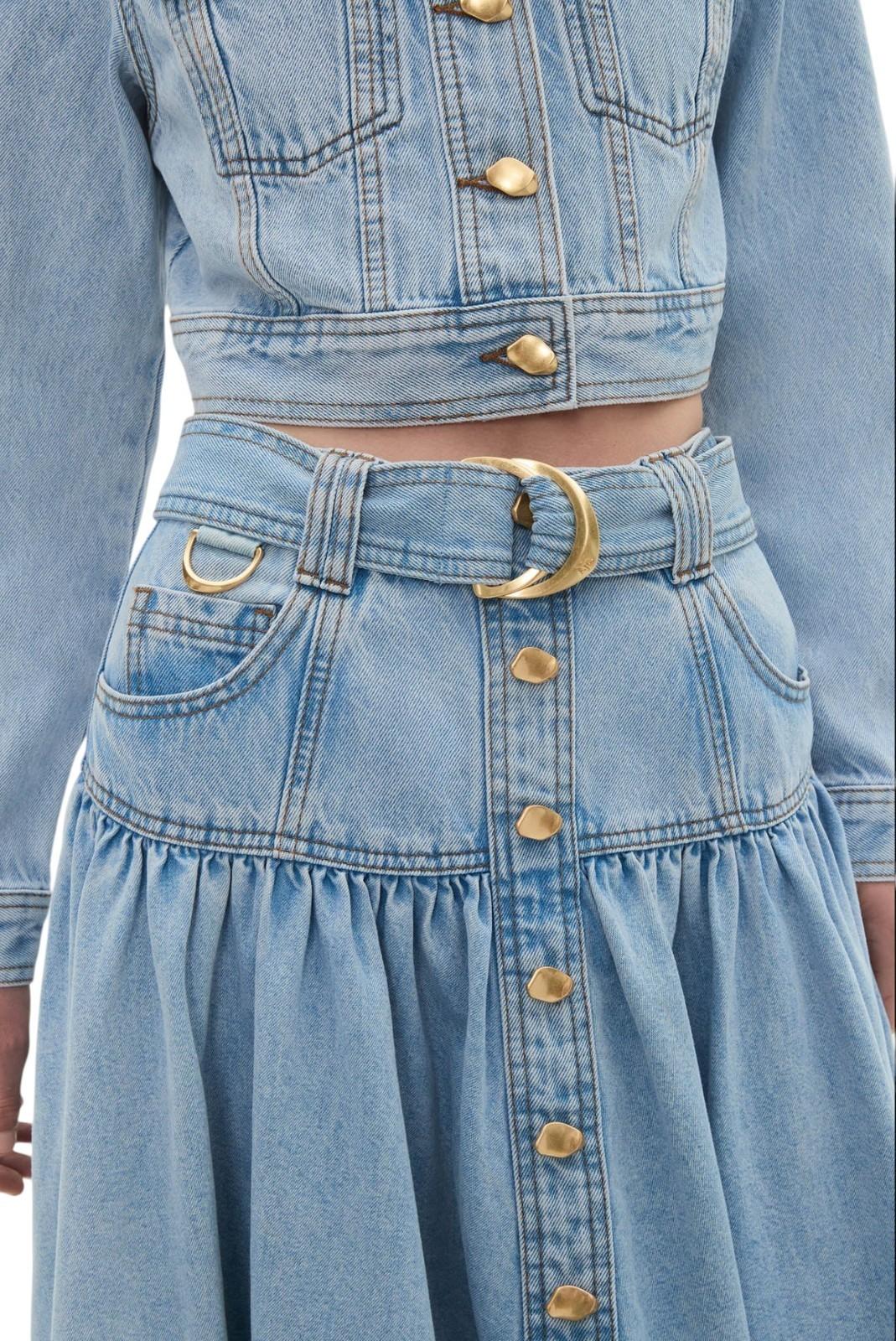 Denim jacket and skirt with gold buttons and belt buckle on a person.