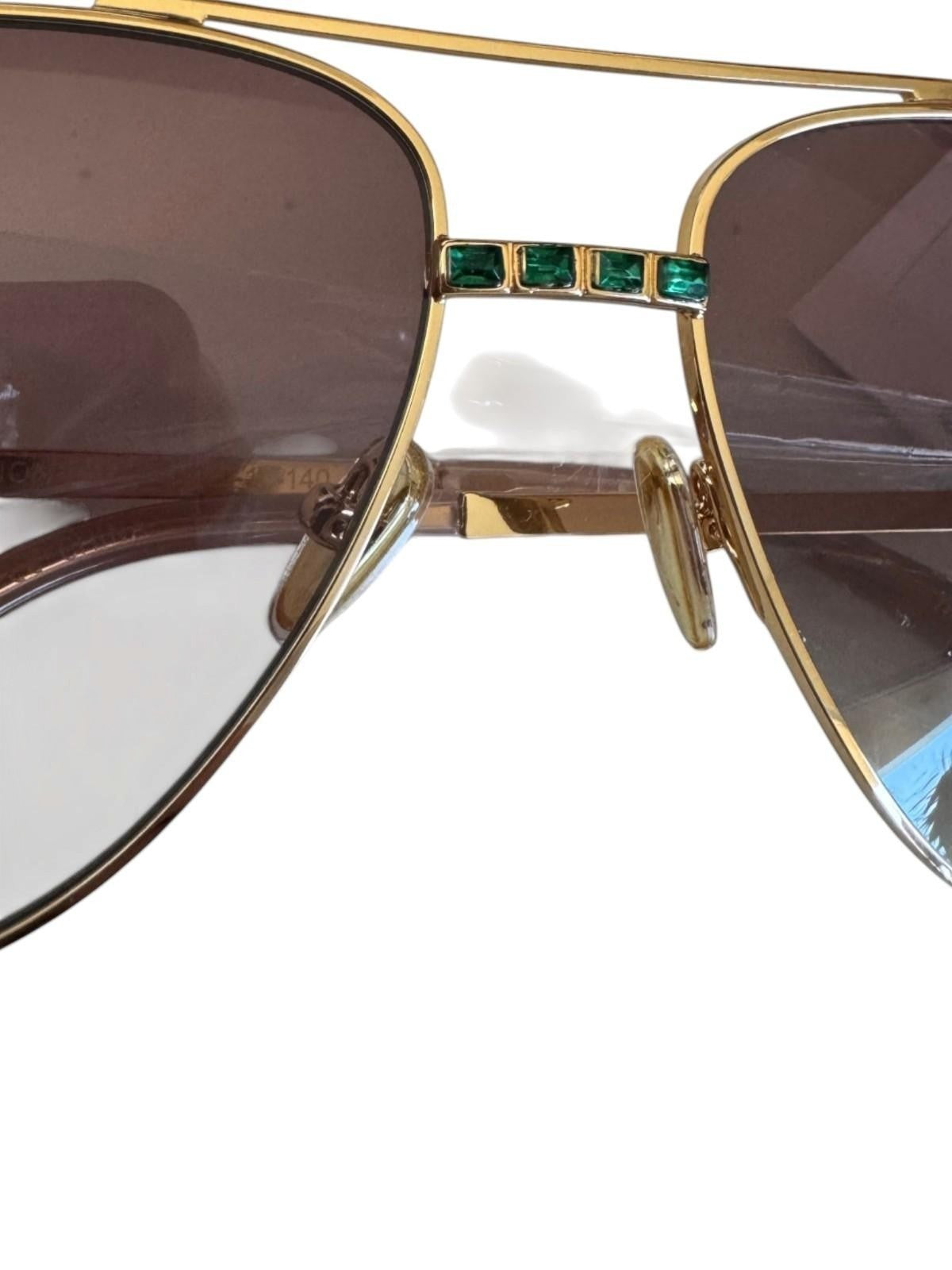 Naked Pear Camilla Nothing in Moderation aviator sunglasses with gold frames, brown gradient lenses, and green crystals.