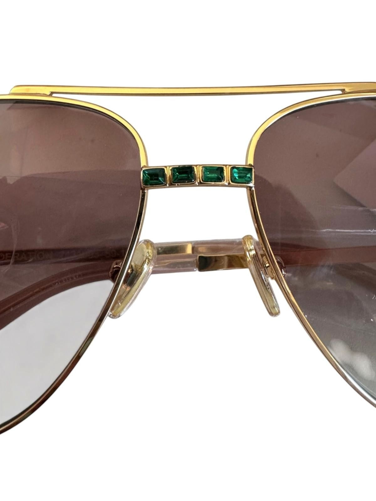 Naked Pear Camilla Nothing in Moderation aviator sunglasses with gold frames, brown gradient lenses, and green crystals