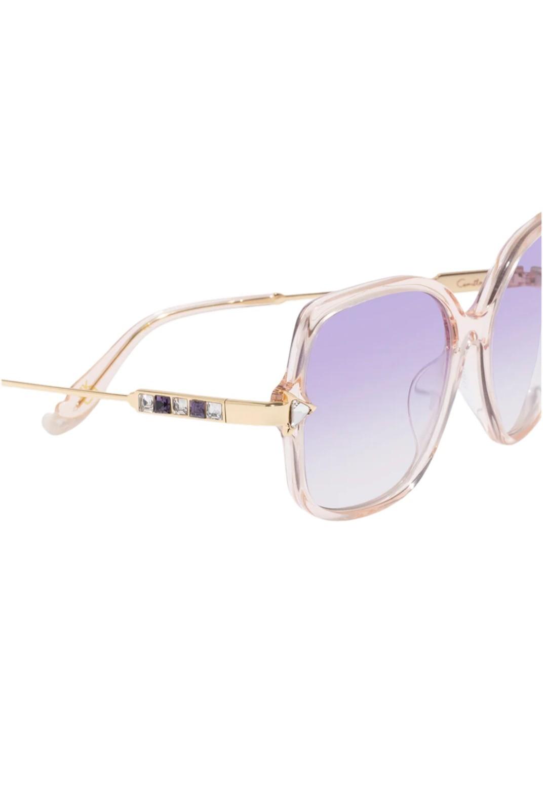 Sunglasses with gold frame and purple lenses on a white background