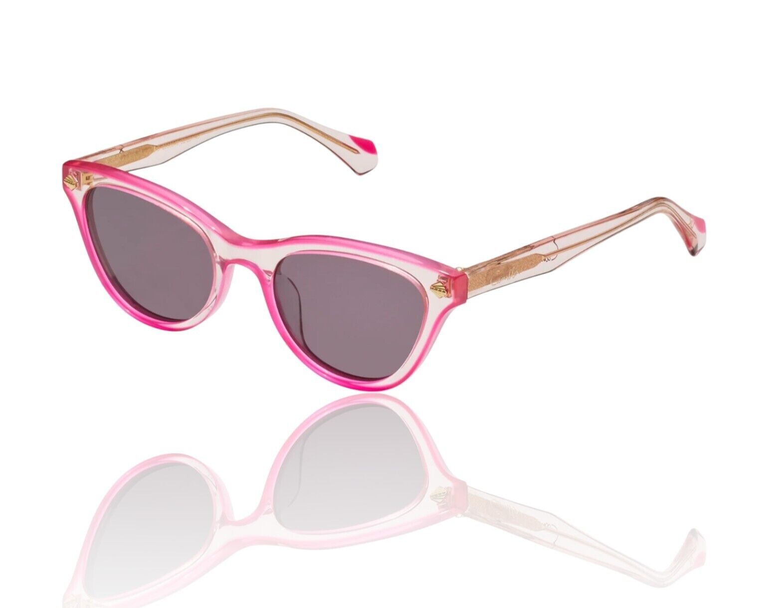 A pair of pink and clear acetate cat-eye style sunglasses with a vintage-inspired design, featuring grey mono lenses and gold foil details.