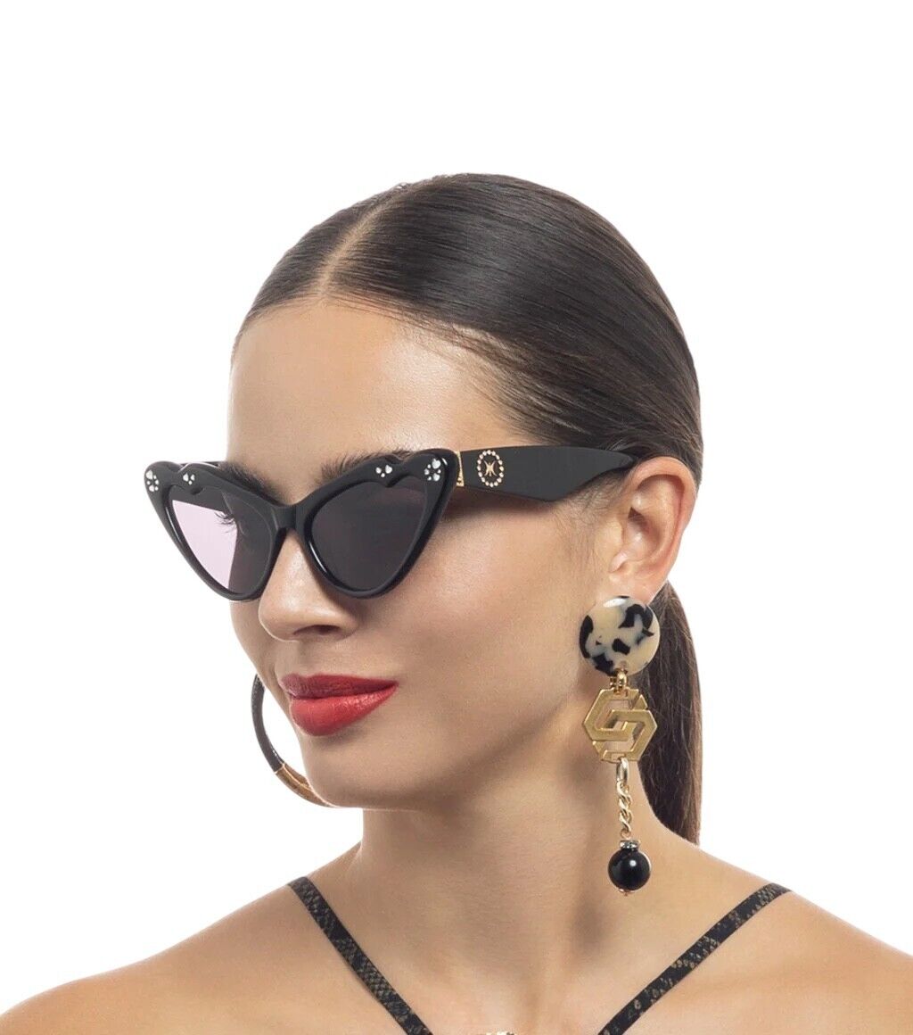 A woman wearing black acetate, crystal embellished cat eye sunglasses with butterfly curves, featuring gold wire core and hinges.