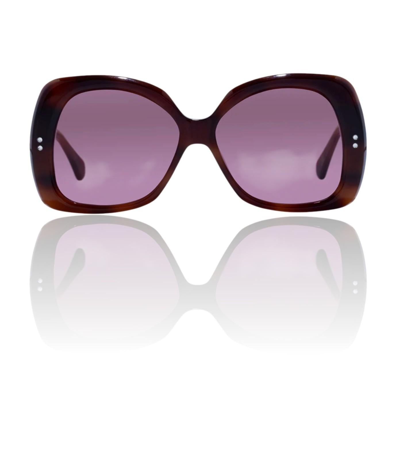 Sunglasses with tortoiseshell frame and purple lenses on a white background