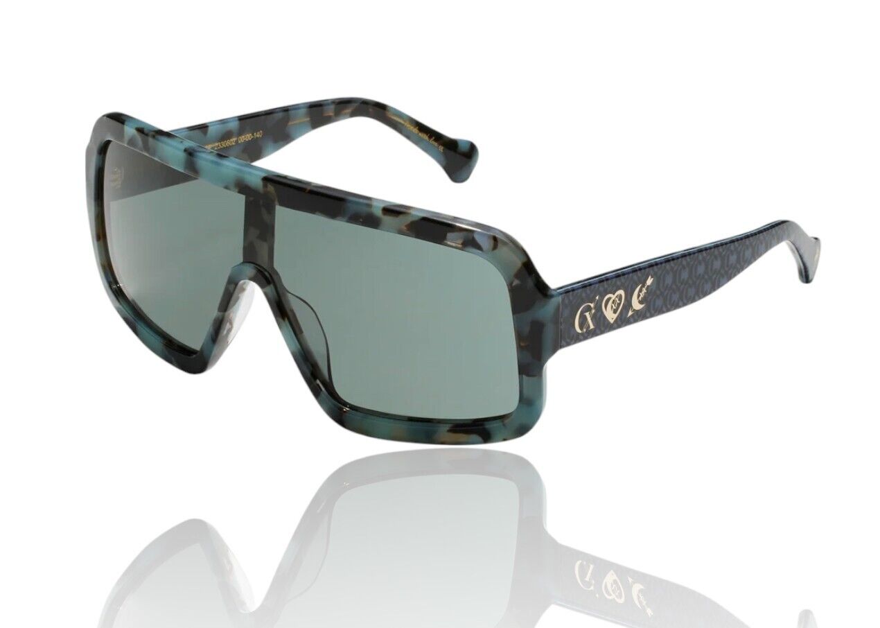 A pair of oversized shield-shaped sunglasses with blue tortoiseshell pattern and monogram accents. The sunglasses have green lenses and feature handcrafted metal details and the 'Camilla' logo at the temples.