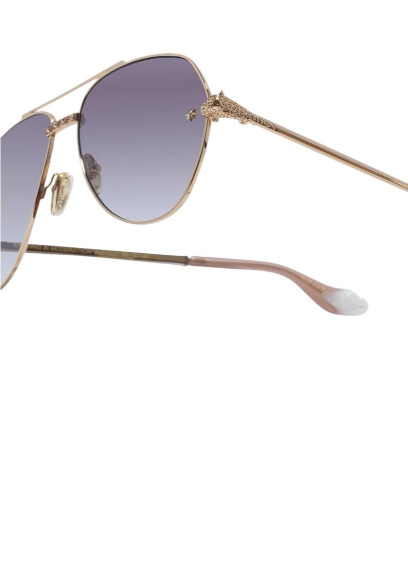 Gold-framed sunglasses with gradient purple lenses on a white background