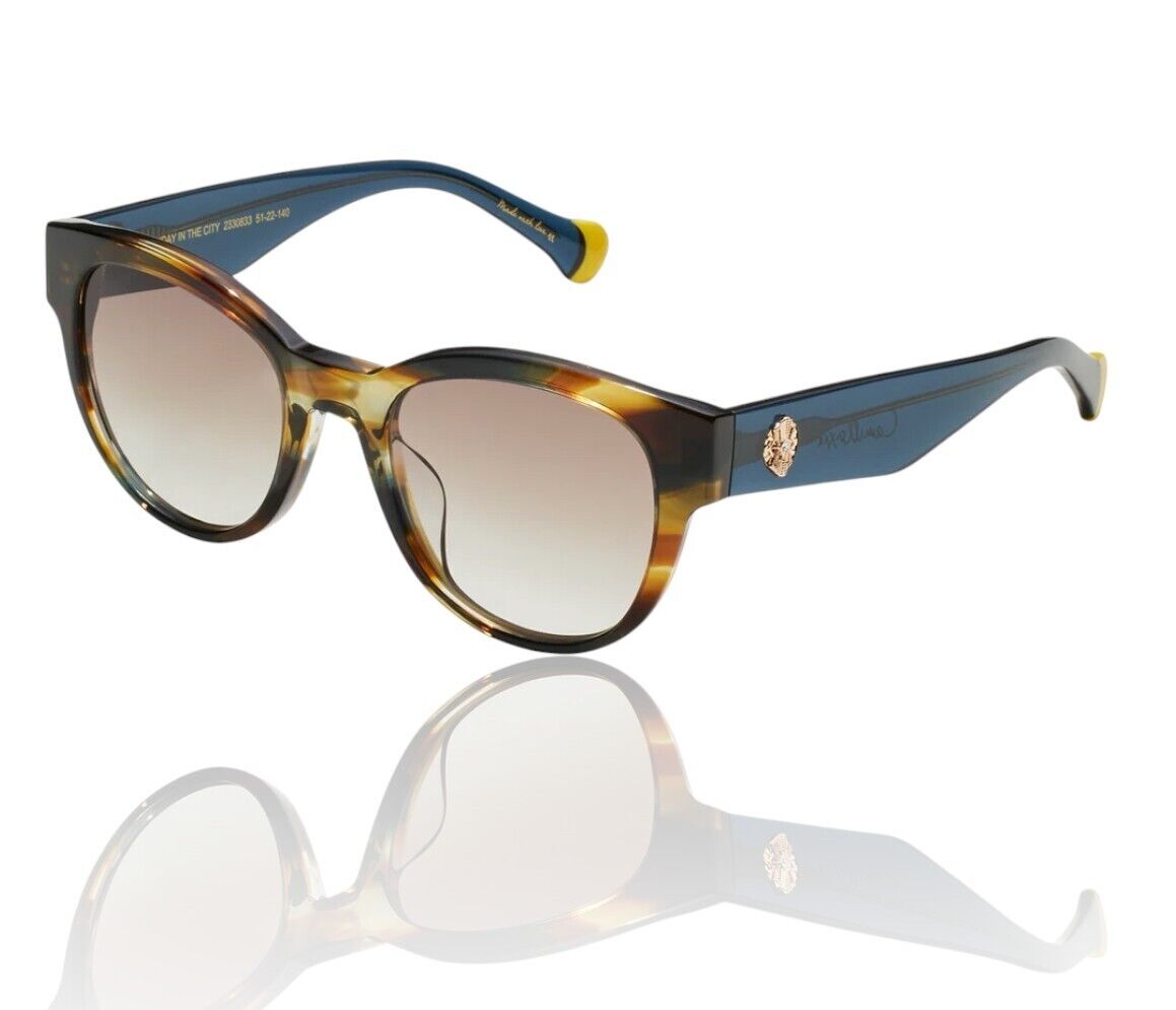 A pair of round, acetate sunglasses with brown and blue arms, featuring a crystal detail on one temple and a distinctive Camilla tip shape.