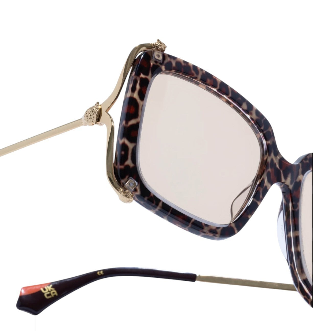 Sunglasses with leopard print frame and gold accents on a white background