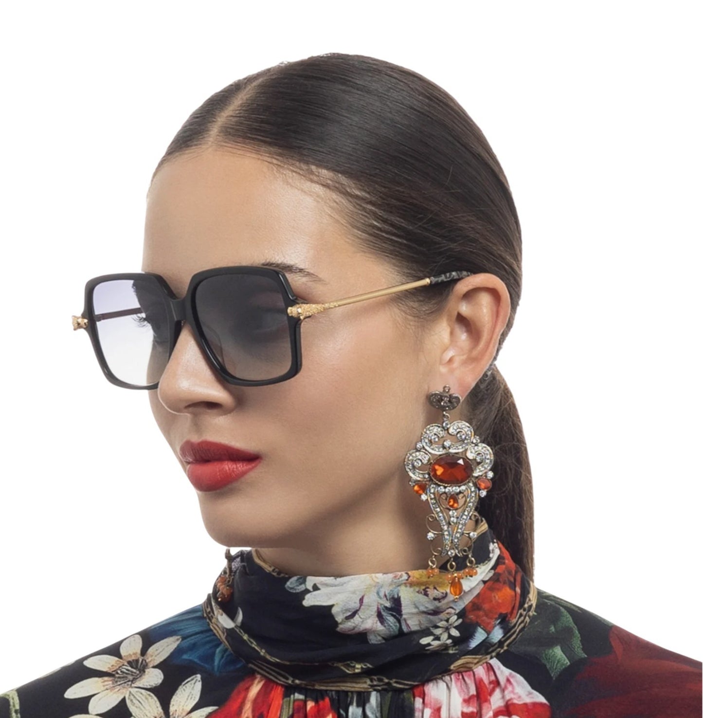Woman wearing sunglasses and a colorful scarf with a white background