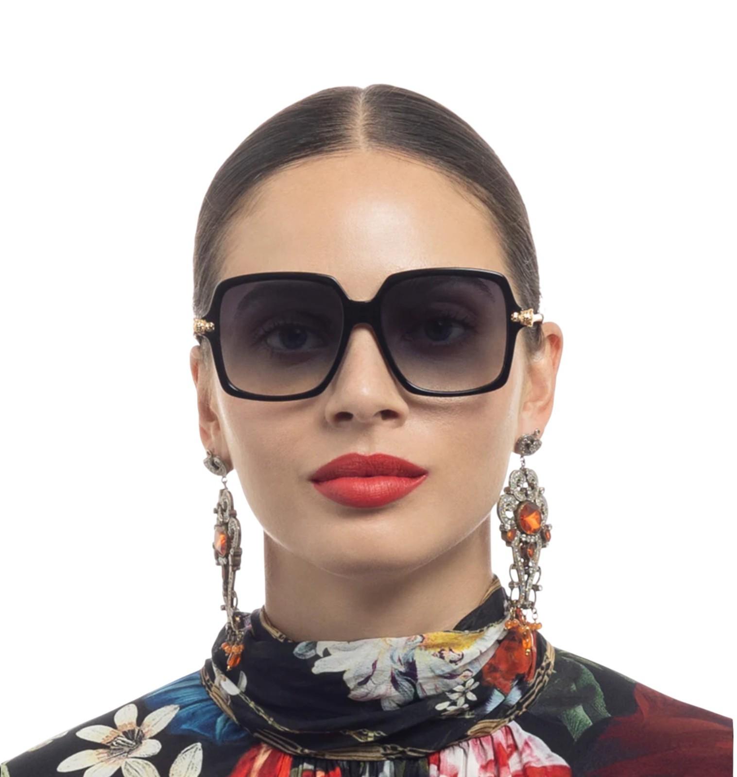 Woman wearing large sunglasses and a colorful scarf with a white background