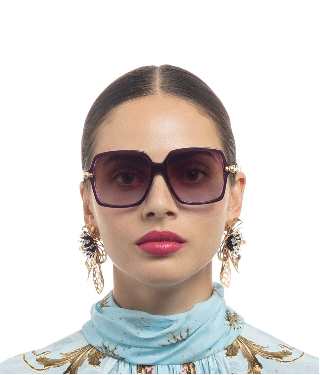 Woman wearing large sunglasses with a plain background