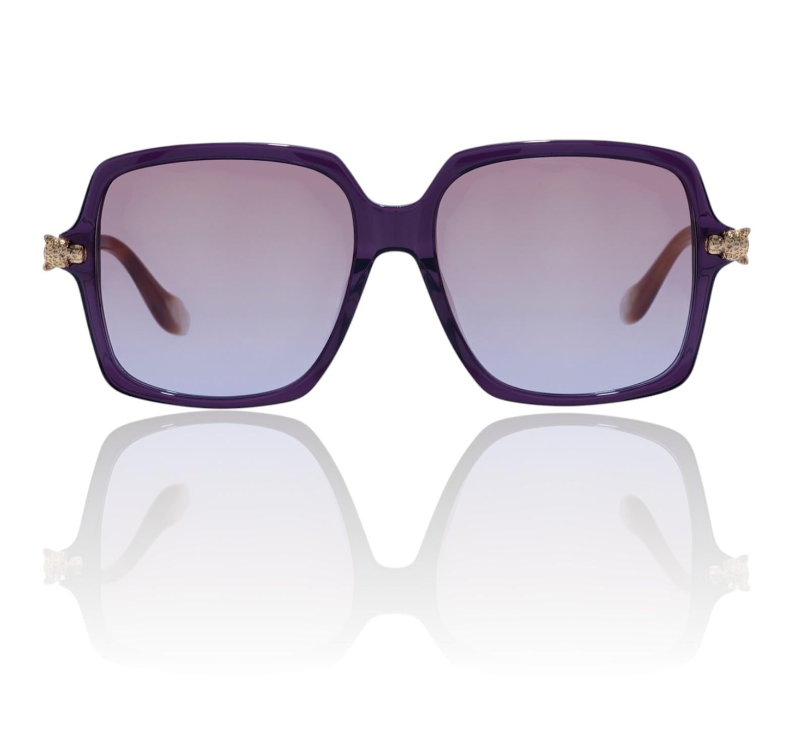 Purple sunglasses with gold accents on a reflective white surface