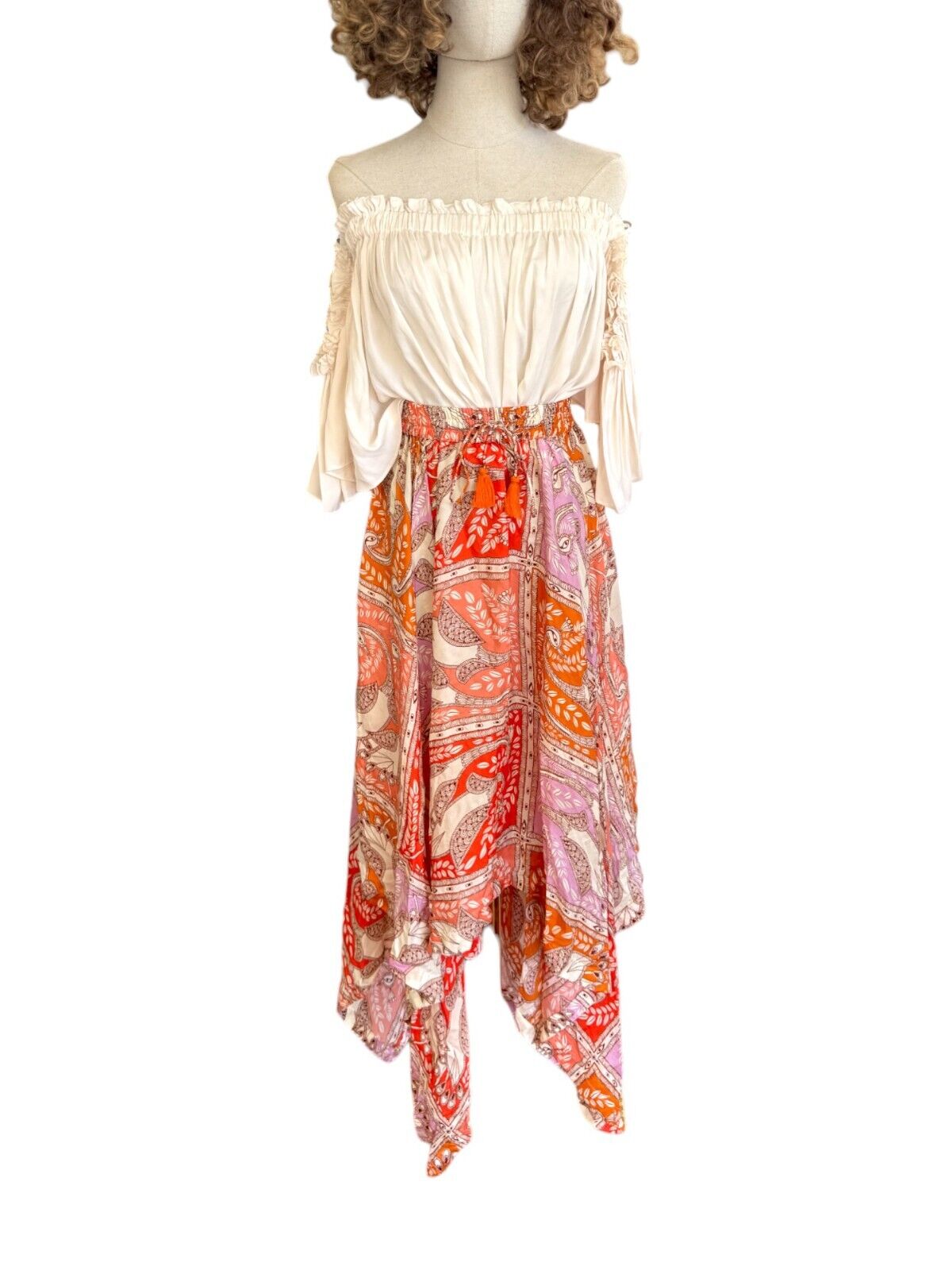 A mannequin displaying a HANNAH ARTWEAR Delila Midi Skirt with orange and red floral print, featuring a high-waisted design and a drawstring waist.