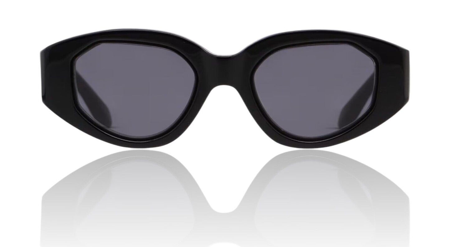 Naked Pear Karen Walker Castaway sunglasses featuring a black oval acetate frame with angular details and grey lenses.