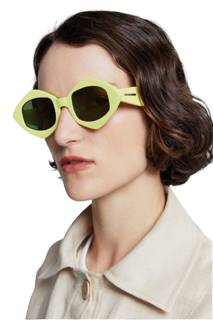 Model wearing Naked Pear Karen Walker Diamond Dice sunglasses in neon yellow bio-acetate with dark khaki lenses.