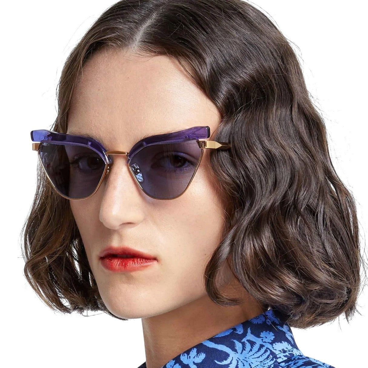 Model wearing Naked Pear Karen Walker Fantasia cat eye sunglasses with powder blue acetate frames and gold metal details.