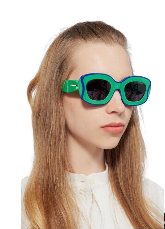 Naked Pear Karen Walker Field Trip sunglasses in grasshopper green acetate with blue wavy trim and dark smoke lenses.