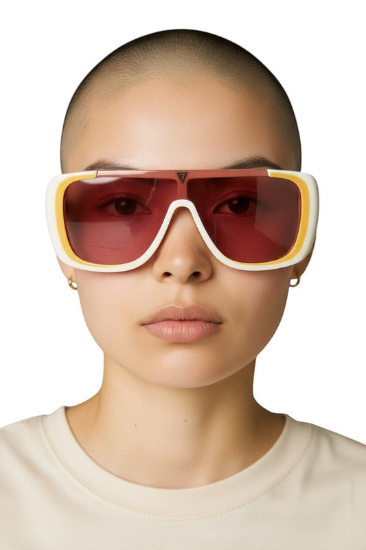 Model wearing Naked Pear Karen Walker Hexed shield sunglasses with an ivory acetate frame and pink-tinted lenses.
