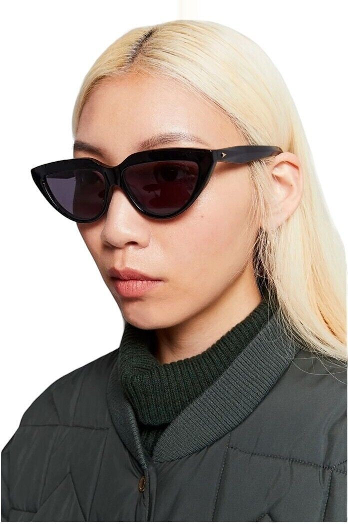 Model wearing Naked Pear Karen Walker Lash Splash black cat-eye bio-acetate sunglasses with grey mono lenses
