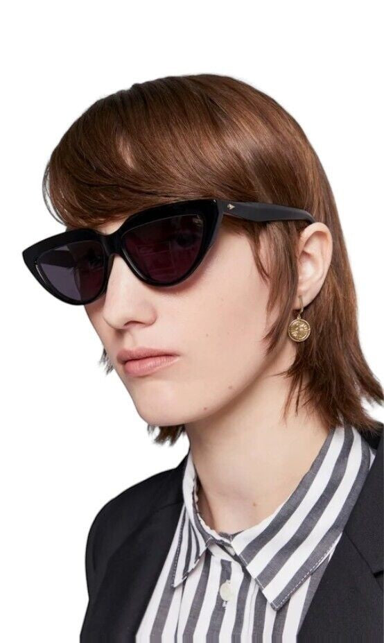 Model wearing Naked Pear Karen Walker Lash Splash black cat-eye sunglasses with grey mono lenses and arrow hardware